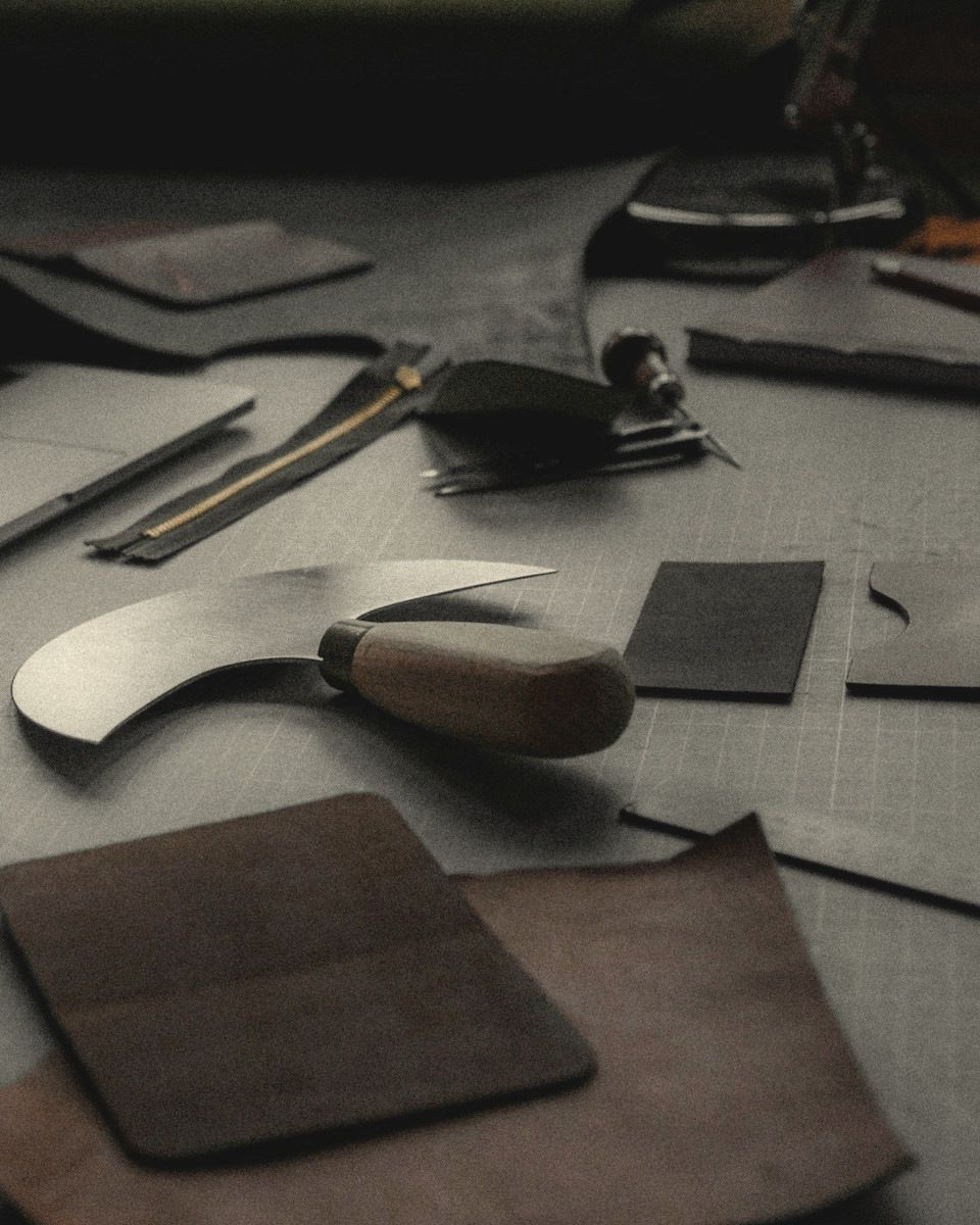 Round knife and leather panels on a workshop cutting table