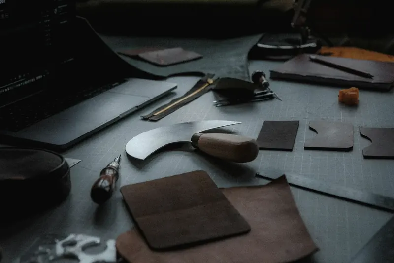 Cut leather pieces and a round head knife on the cutting table