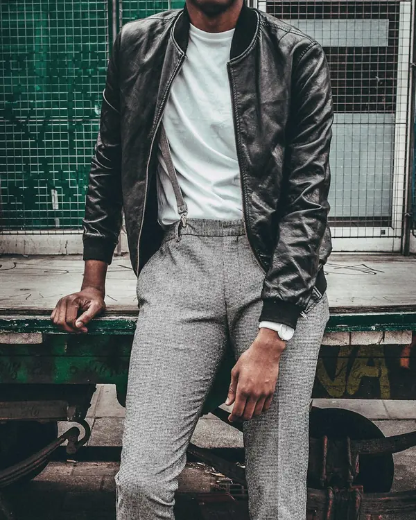 Black leather bomber jacket with ribbed collar and cuffs, worn over a white tee