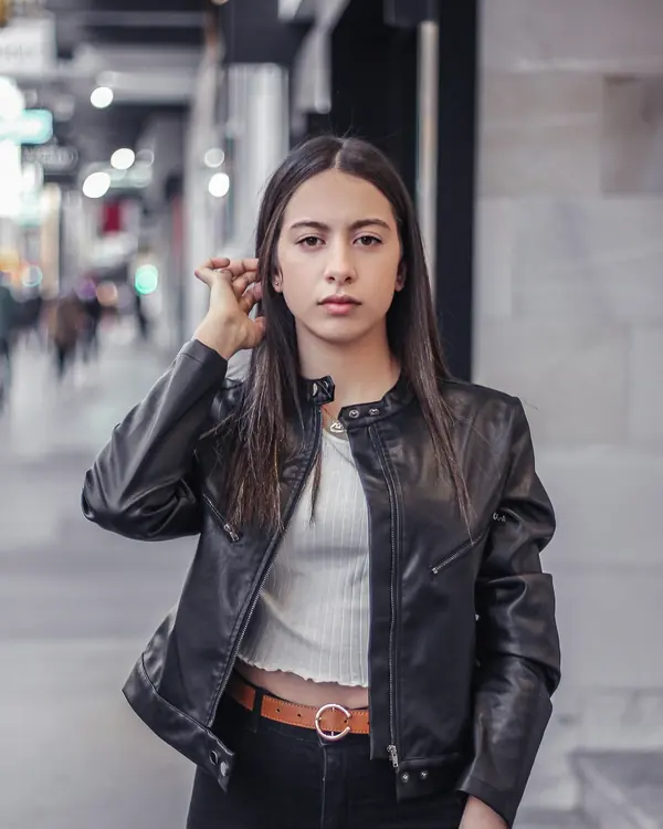 Cropped black leather moto jacket with a band collar, worn with a white rib top