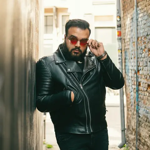 Customer in a black biker jacket and red sunglasses in a laneway